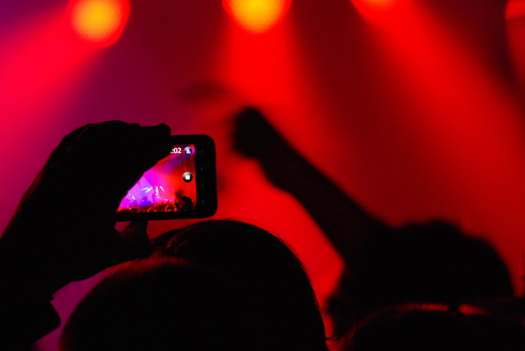 Concert crowd silhouettes under red stage lights